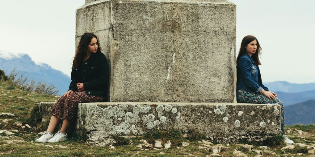 Two women sitting on a monument
